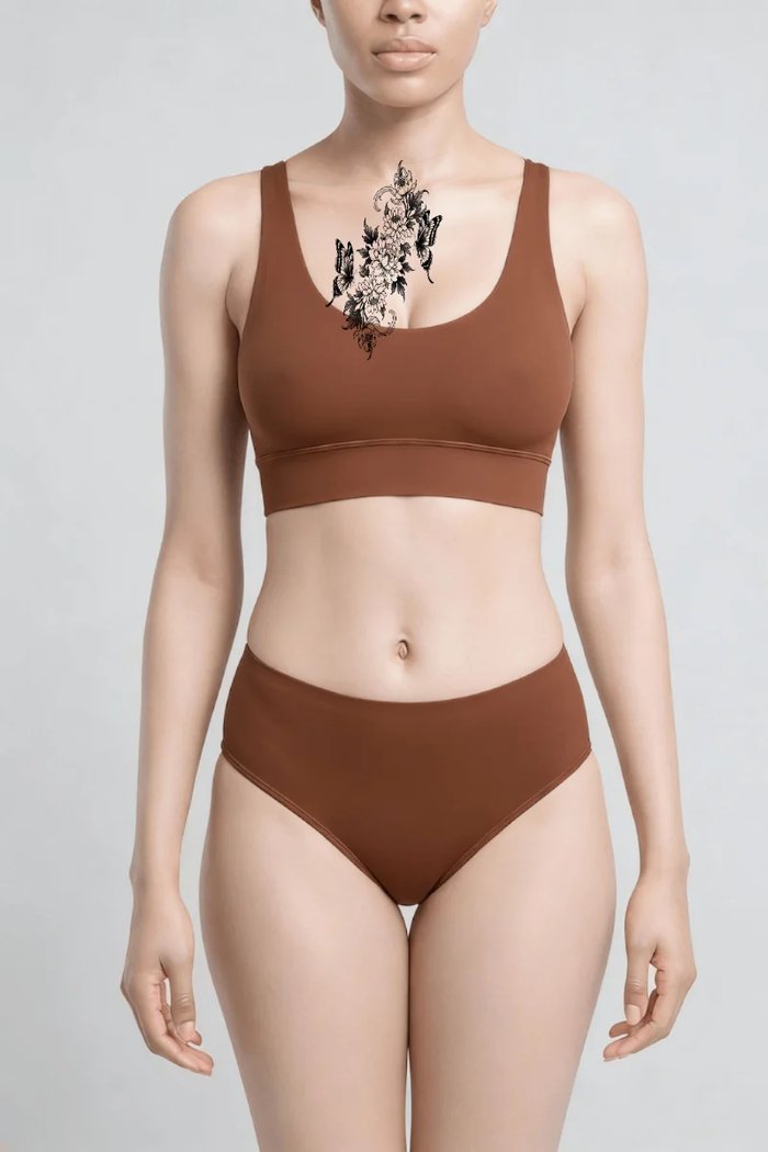 The same photo with a fine-line floral design previewed on the breastbone in 3D